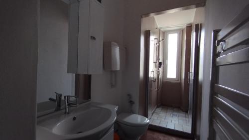 a white bathroom with a sink and a toilet at Antico Borgo Teresiano in Trieste