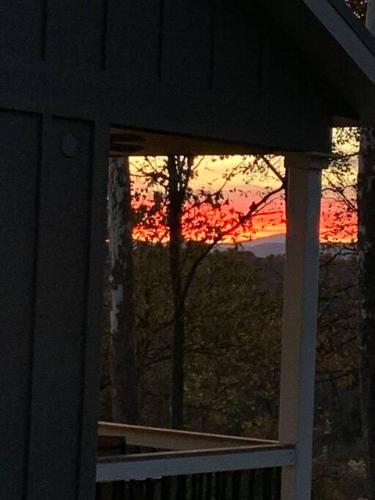 a sunset seen through a window of a house at A beautiful sunset cottage in Hendersonville