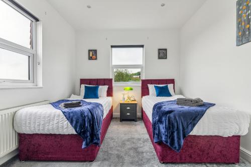 2 posti letto in una camera con blu e rosso di Spacious 3 Bedroom - 2 Full Bath Flat Belverde Erith South East London a Belvedere
