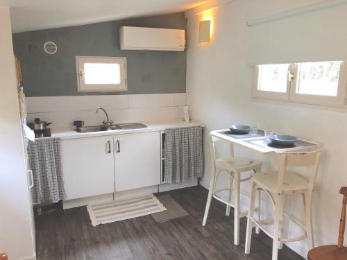 a kitchen with a sink and a table with stools at le cottage in Apremont