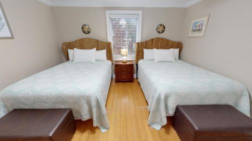 a room with two beds and a table and a window at Brass Rail Villas 109 by Tybee Vacation Rentals in Tybee Island
