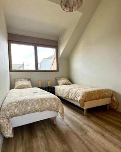 une chambre avec deux lits et une fenêtre dans l'établissement L'urbaine, à Le Pellerin