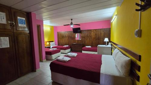 um quarto de hotel com uma cama e um quarto com cor-de-rosa em Villa Termal em Federación