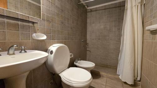 uma casa de banho com um WC branco e um lavatório. em Villa Termal em Federación