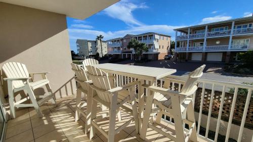 un tavolo bianco e sedie su un balcone di Gull Reef 614 by Tybee Vacation Rentals a Tybee Island