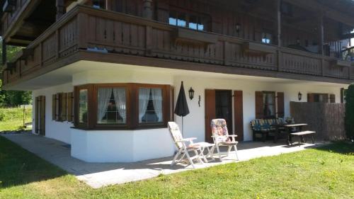 a small house with two chairs and a balcony at Ferienwohnung Nefen in Reit im Winkl