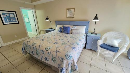 una camera con letto e sedia in vimini di Gull Reef 614 by Tybee Vacation Rentals a Tybee Island