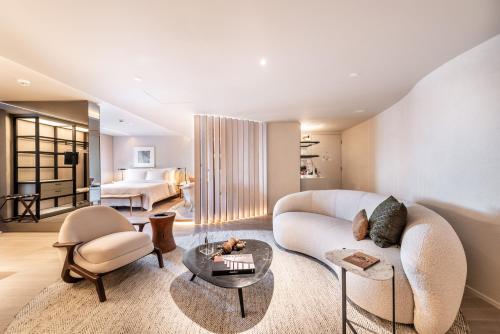 a living room with a white couch and a table at Hotel Unique in Sao Paulo