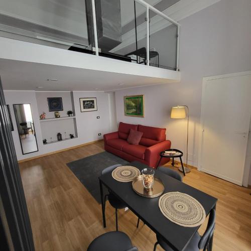 uma sala de estar com um sofá vermelho e uma mesa em Appartamento Noemi Zinghouse CT em Catânia