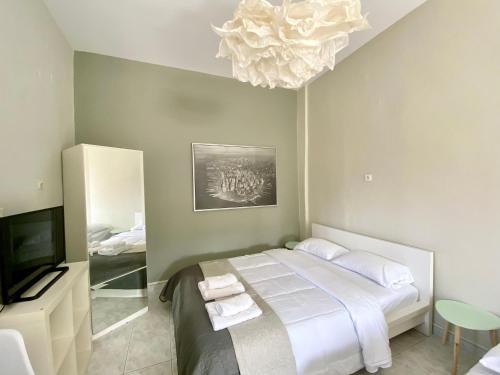 a bedroom with a bed and a television and a chandelier at Venice Studios & Apartments in Stavros