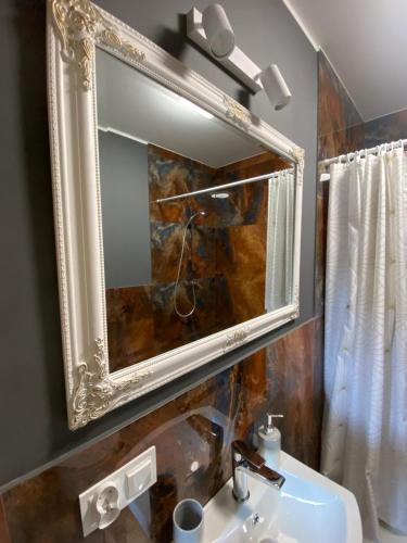 a mirror above a sink in a bathroom at Pokoje u Daniela in Miedzygorze