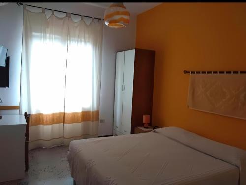 ein Schlafzimmer mit einem Bett und einem großen Fenster in der Unterkunft BB Le Violette in Tortolì