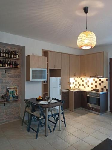 una cucina con tavolo con sedie e frigorifero di Plaka Elounda cozy apartment a Eloúnda