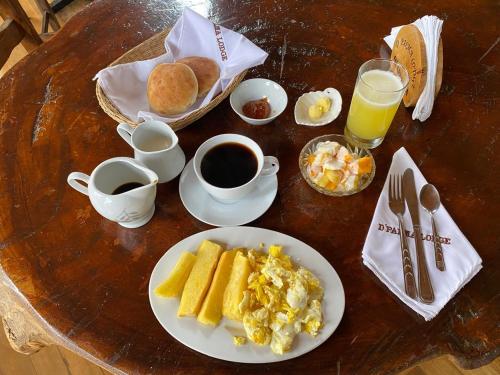 a table with a plate of eggs and coffee and breakfast foods at Cabañas Palma Sky Lodge in Oxapampa