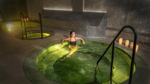 a man in a pool of water in a room at Wellcomm Spa & Hotel in Medellín