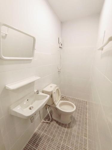 a white bathroom with a toilet and a sink at GO INN BTS Ari in Pratunam