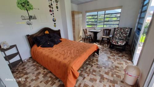 a bedroom with a bed and a table and chairs at Vivienda Rural La Estancia in Duitama