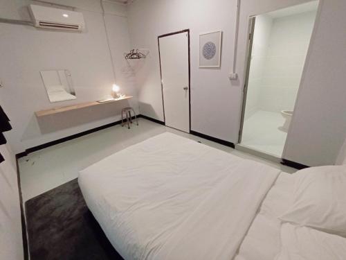 a white room with a bed and a bathroom at GO INN BTS Ari in Pratunam
