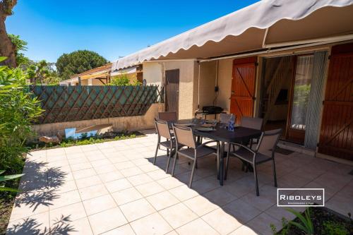 un patio avec une table et des chaises dessus dans l'établissement Villa rénovée climatisée à 500m de la plage, à Vias
