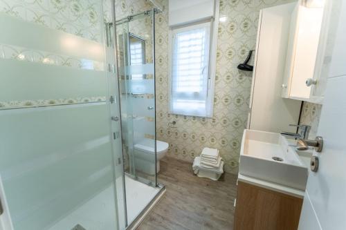 uma casa de banho com um chuveiro, um WC e um lavatório. em luminoso apartamento en maliaño em Maliaño
