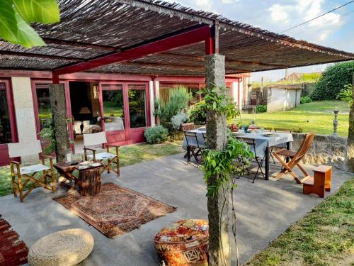 a patio with a table and chairs under a roof at Casa Justininho in Ponte de Lima