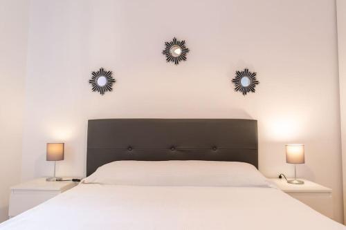 a bedroom with a bed with two mirrors on the wall at luminoso apartamento en maliaño in Maliaño