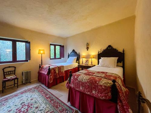 a bedroom with two beds and a rug at Casa Justininho in Ponte de Lima