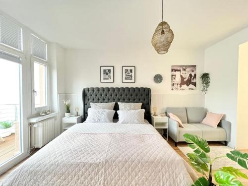a bedroom with a large bed and a couch at Luxus Appartement in zentrale Lage von Siegburg in Siegburg