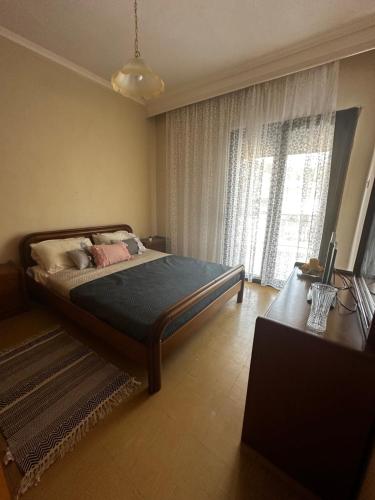 a bedroom with a bed and a large window at Zozefina apartment in Nea Peramos