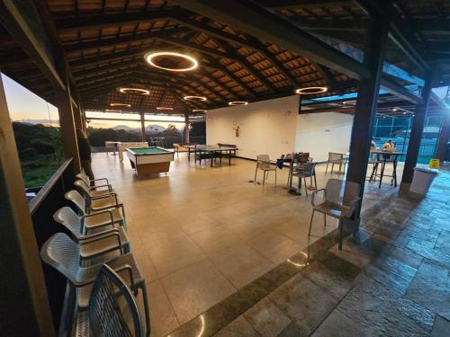 a room with tables and chairs and a pool table at Resort QSB - Um novo padrão de conforto e lazer no coração da cidade in Pirenópolis