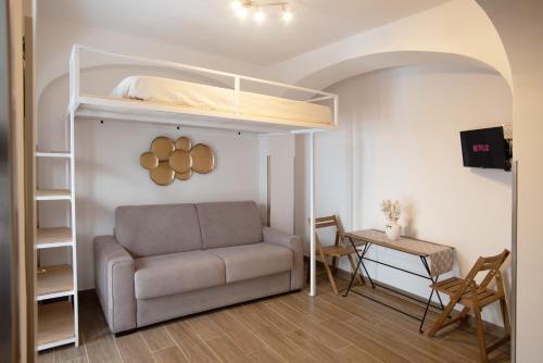 ein Wohnzimmer mit einem Sofa und einem Etagenbett in der Unterkunft Il Vicoletto sul Mare in Ischia