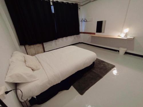 a bedroom with a white bed in a room at GO INN BTS Ari in Pratunam
