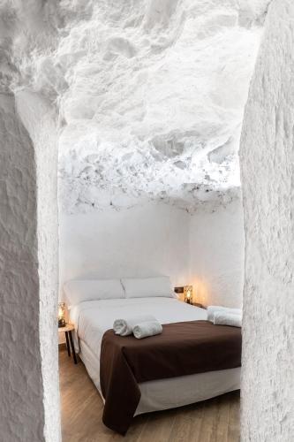 a bedroom with a bed in a white wall at Complejo Mirador del Castillo in Alcalá del Júcar