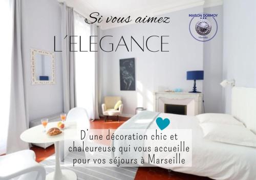 a white bedroom with a bed and a table at Maison Dormoy in Marseille