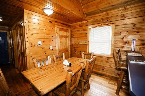 a wooden dining room with a wooden table and chairs at The Cabins at Pine Haven - Beckley in Beaver
