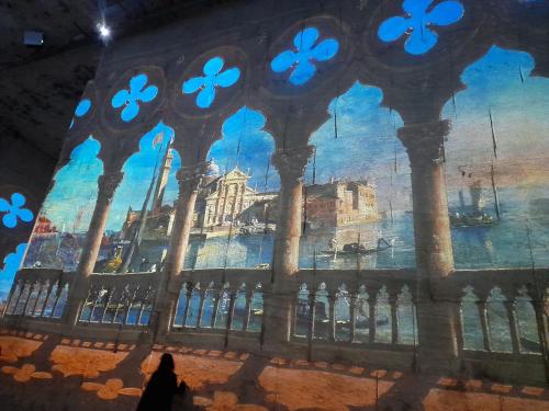 a person walking in front of a painting of a building at Le Mas du Lac in Uzès