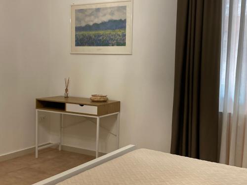 a bedroom with a bed and a table and a picture at La Ginestra Apartment in Marsala