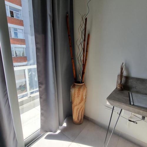 a vase sitting in a corner next to a window at AZ Suites Resistencia in Resistencia