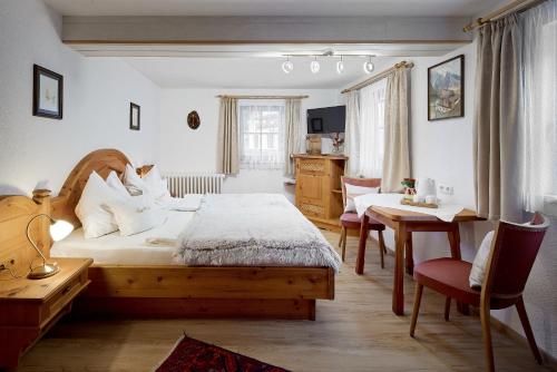 1 dormitorio con 1 cama, mesa y sillas en Pension Heilbad Burgwies, en Stuhlfelden