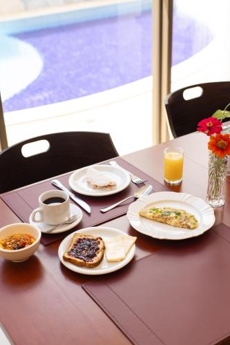 Una mesa con platos de comida y bebidas sobre ella. en Nobile Hotel Araripina, en Araripina