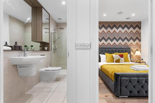 uma casa de banho com uma cama e um lavatório. em Spacious 1 Bed Flat - Near Heathrow - UB3 London em Londres