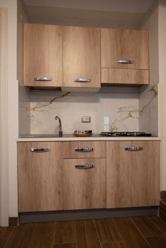 a kitchen with wooden cabinets and a sink at Il Vicoletto sul Mare in Ischia