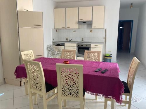 cocina con mesa y mantel púrpura en Résidence Jlidi, en Midoun