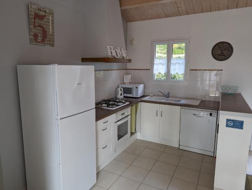 eine Küche mit weißen Geräten und einem weißen Kühlschrank in der Unterkunft La Grande Margotte by Edgar et Alfred in Saint-Georges-dʼOléron