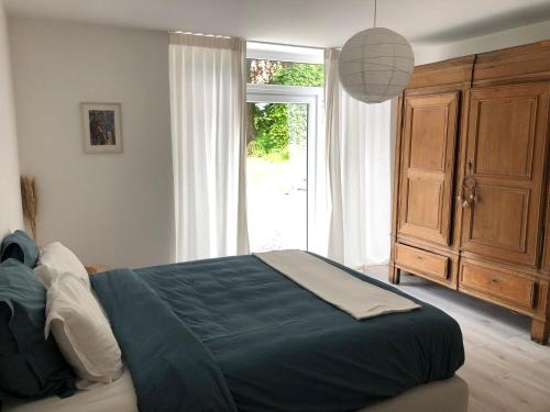 sypialnia z dużym łóżkiem i dużym oknem w obiekcie Les écuries - Maison entière w mieście Spa