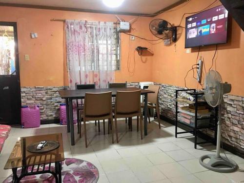 a dining room with a table and chairs and a tv at 7pax, 2 AC BR,Videoke,Games,Netflix,Cook,Parking in Rodriguez