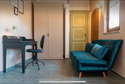 a living room with a blue couch and a desk at Villa Amanda in Scorcetoli