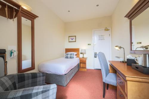 a bedroom with a bed and a desk and a chair at Old Waverley Hotel in Edinburgh