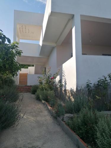 a white house with some plants in front of it at Fuga in montagna in Zawya
