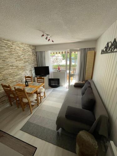 a living room with a couch and a table at Cosy 2 pièces proche Châtel in Abondance